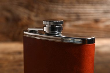 Ahşap arka planda yeni bir cep şişesi, yakın plan.