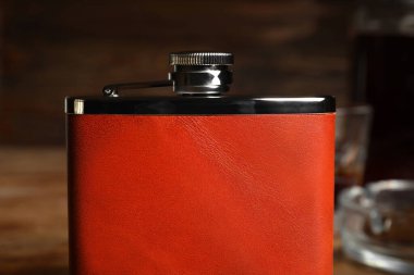 Ahşap arka planda yeni bir cep şişesi, yakın plan.