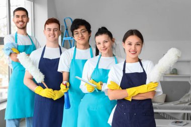 Odada temizlik malzemeleri olan bir grup genç hademe.