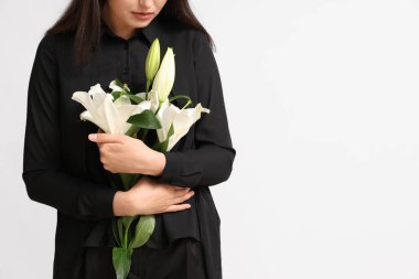 Beyaz arka planda bir buket nilüfer çiçeği olan genç bir kadın.