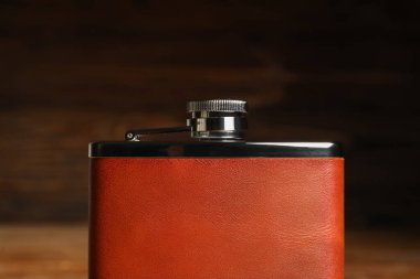 Ahşap arka planda yeni bir cep şişesi, yakın plan.