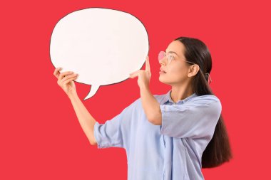 Kırmızı arka planda boş konuşma balonu olan genç bir kadın.