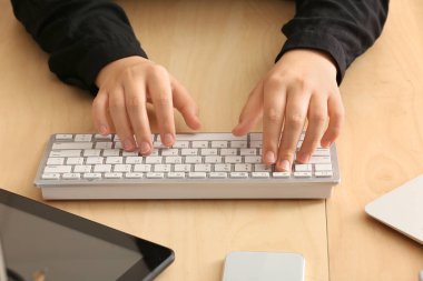 Ofisteki bilgisayar klavyesinde yazan kadın programcı, kapat