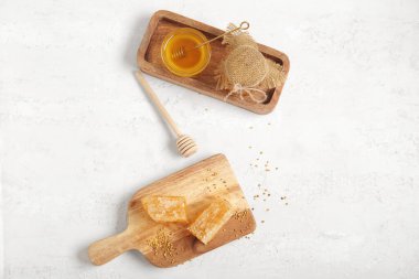 Bir kase tatlı bal, taraklar ve arka planda arı poleni