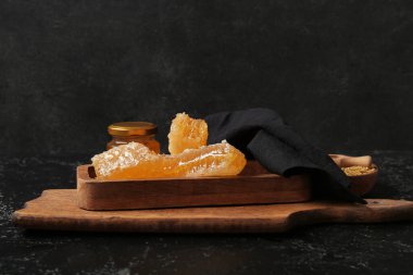 Koyu arkaplanda bal petekleri olan ahşap tahta tahta.