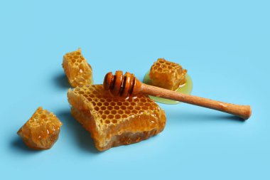 Mavi arka planda tatlı bal petekleri ve dipper