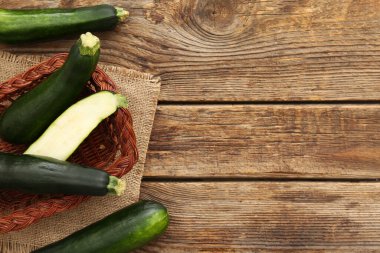 Tahta arka planda yeşil kabaklı sepet.