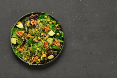 Siyah arka planda taze salata tabağı.