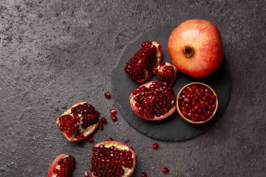 Taze nar ve koyu arkaplanda bir kase tohum.