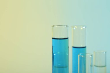 Renkli arka planda farklı numunelere sahip test tüpleri, yakın plan