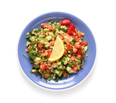 Lezzetli tabakta salata ve beyaz arka planda limon dilimi.