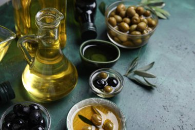 Yeşil arka planda bir sürahi dolusu taze zeytinyağı.