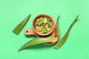 Aloe vera yapraklı tahta ve kase kesme yeşil arka planda