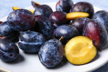 Mavi arka planda taze erik tabağı