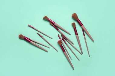 Turkuaz arka planda makyaj fırçaları