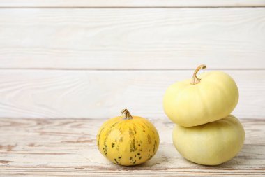 Beyaz ahşap arka planda farklı taze balkabakları