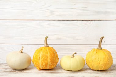 Beyaz ahşap arka planda farklı taze balkabakları