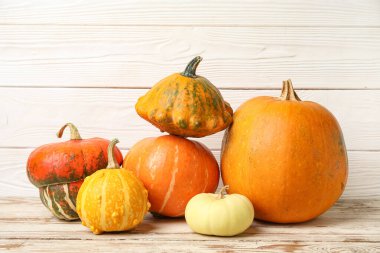 Beyaz ahşap arka planda farklı taze balkabakları