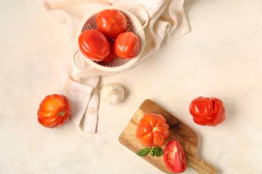 Tahta tahta ve taze olgun domates kevaşesi ve beyaz arka planda farklı baharatlar.