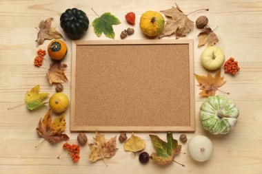 Kahverengi ahşap arka planda tahta, balkabağı ve sonbahar yapraklarıyla kompozisyon