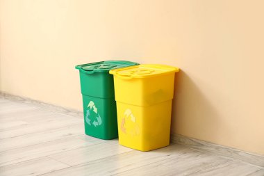 Bej duvarın yanındaki çöpler için konteynırlar. Geri dönüşüm kavramı