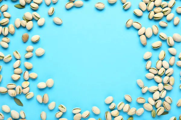 Mavi arka planda lezzetli fıstıklardan yapılmış çerçeve