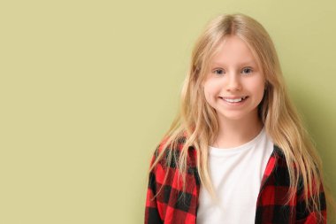 Yeşil arka planda sağlıklı dişleri olan mutlu küçük kız.