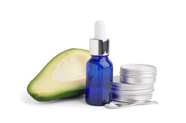 Beyaz arka planda taze avokadosu olan kozmetik ürünleri.