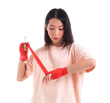 Young Asian woman applying armbands before practicing martial arts on white background clipart