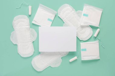 Regl pedleri ve turkuaz arka planda tamponları olan boş bir kağıt.