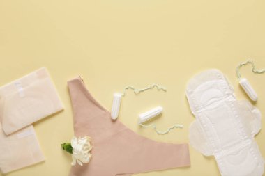 Sarı arka planda tampon ve iç çamaşırlı adet pedleri