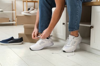 Butikte şık ayakkabılar deneyen adam.