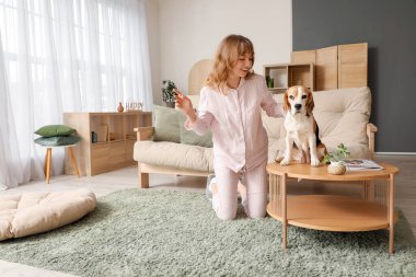 Evde kahve masasında sevimli bir av köpeği olan genç bir kadın.