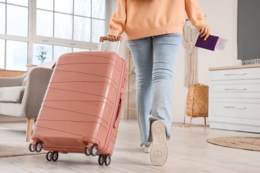 Bavulu ve pasaportu olan kadın turist eve dönüyor.