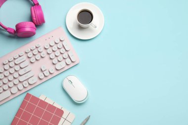 PC klavye, fare, kulaklık, kahve ve kırtasiye malzemesi mavi arkaplanda