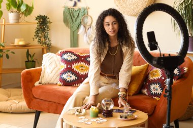 Büyülü özellikleri olan genç Afro-Amerikan cadı evinde video kaydı yapıyor.