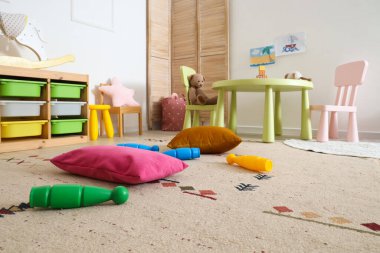 Anaokulunda oyuncakları ve minderleri olan bir oyun odası.