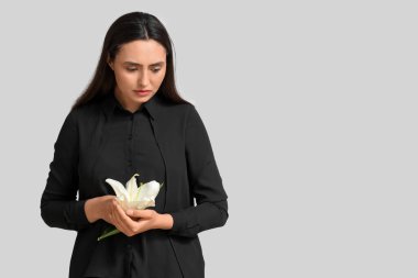 Beyaz arka planda zambak çiçeği olan genç bir kadın.