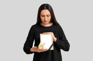 Nilüfer çiçeği ve beyaz arka planda fotoğraf çerçevesi olan genç bir kadın.