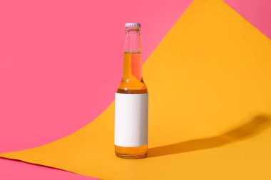 Renkli arka planda bir şişe soğuk bira.