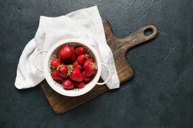 Siyah arka planda taze çilekli Colander.