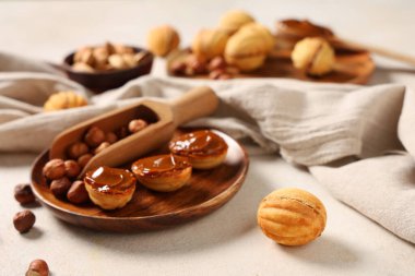 Lezzetli ceviz şekilli kurabiyeler haşlanmış süt ve beyaz grunge masasında fındık, yakın plan.