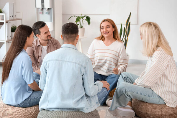 Smiling mature woman talking at group therapy session