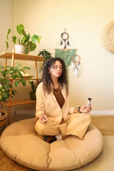 stock image Young African-American witch with stone and incense meditating at home