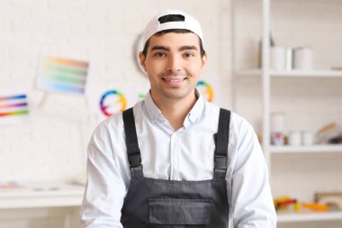 Yakışıklı erkek ressam odada gülümsüyor, yakın plan.