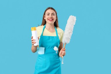 Oda spreyi ve toz bezi olan genç bir kadın.