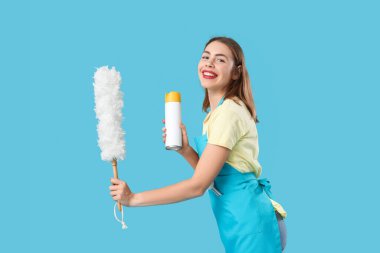 Oda spreyi ve toz bezi olan genç bir kadın.