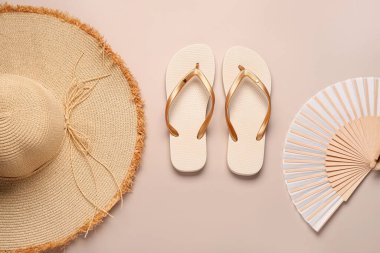 Hasır şapkalı ve fanı bej arka planda olan kadın tarzı terlikler.