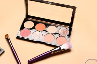 Turuncu arka planda farklı dekoratif kozmetik ürünler