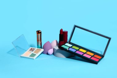 Mavi arka planda farklı makyaj ürünleri